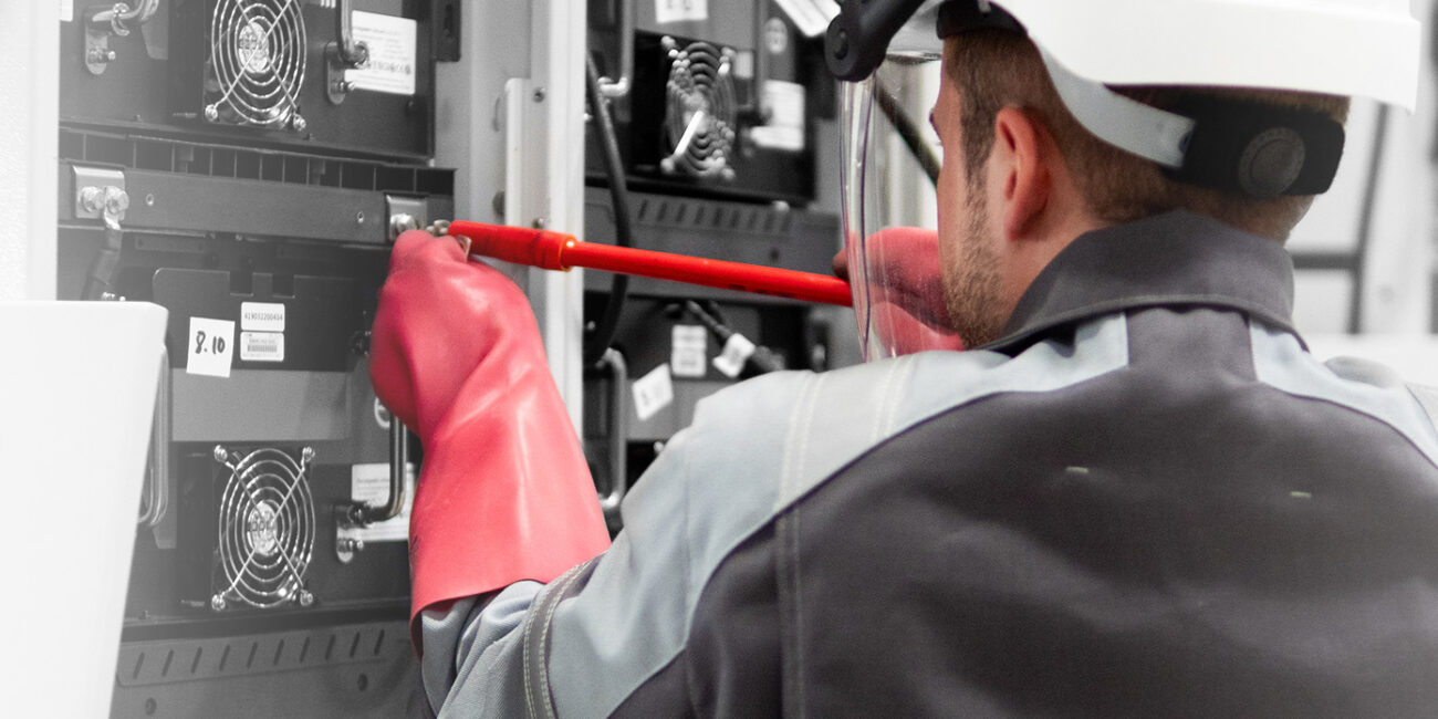Mitarbeiter bestückt Ladestation mit Lithium-Ionen-Batterien