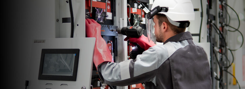 Mitarbeiter bestückt Ladestation mit Lithium-Ionen-Batterien