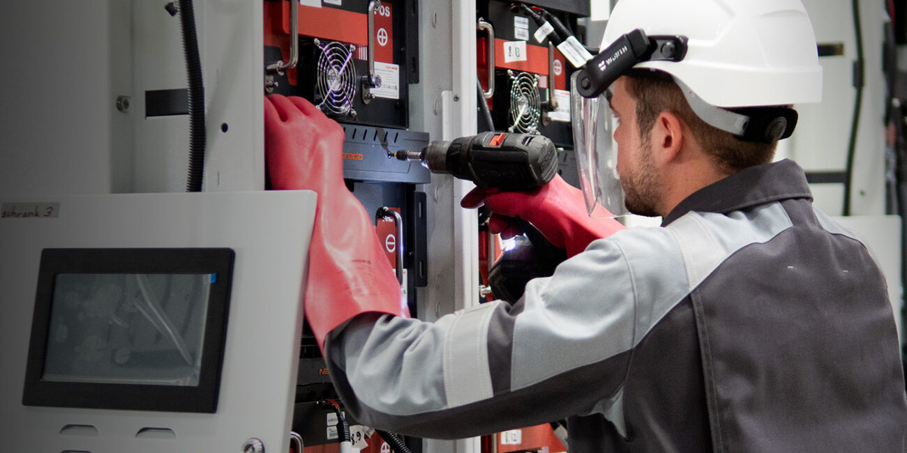 Mitarbeiter bestückt Ladestation mit Lithium-Ionen-Batterien